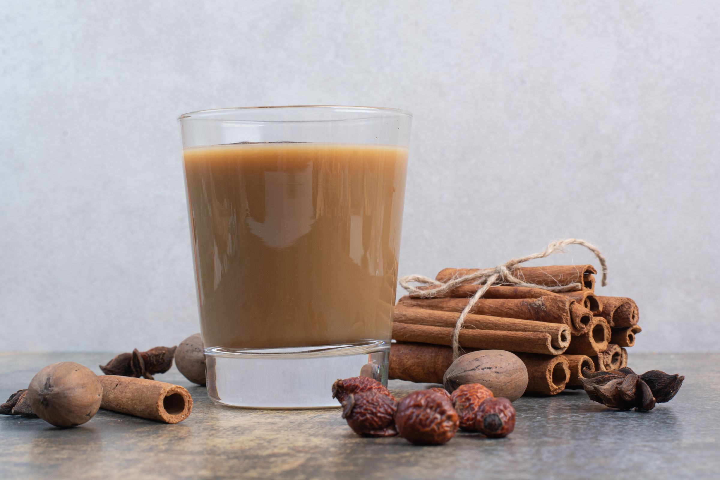 Coffee cup with cinnamon sticks and marble background